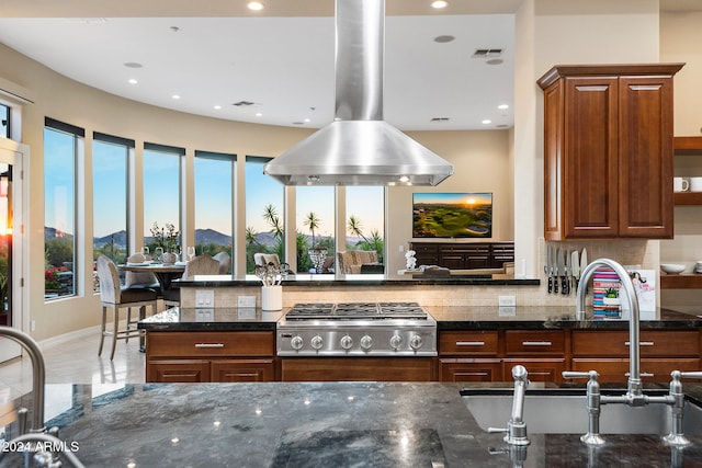 kitchen with stainless steel gas stovetop, sink, and dark stone counters