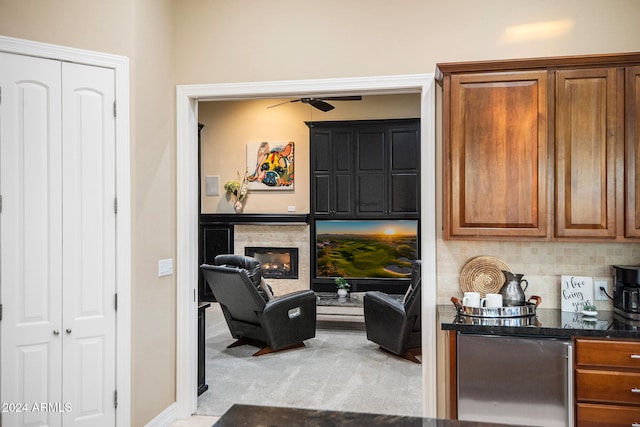 living area with light colored carpet and ceiling fan