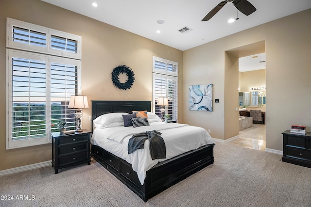 bedroom featuring ensuite bath, light carpet, and ceiling fan