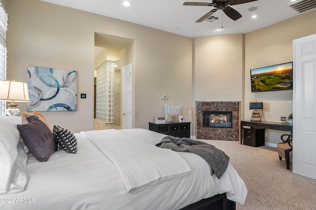 bedroom with carpet floors, a high end fireplace, and ceiling fan