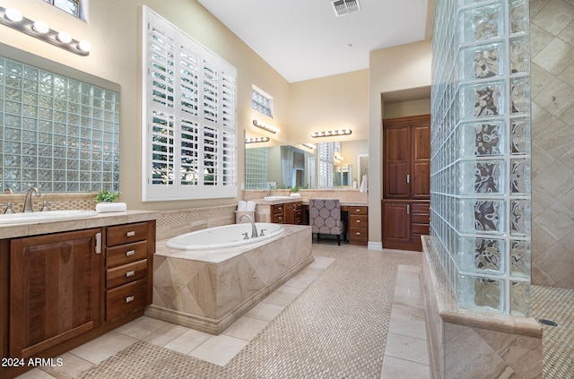 bathroom with vanity, tile patterned floors, and tiled bath