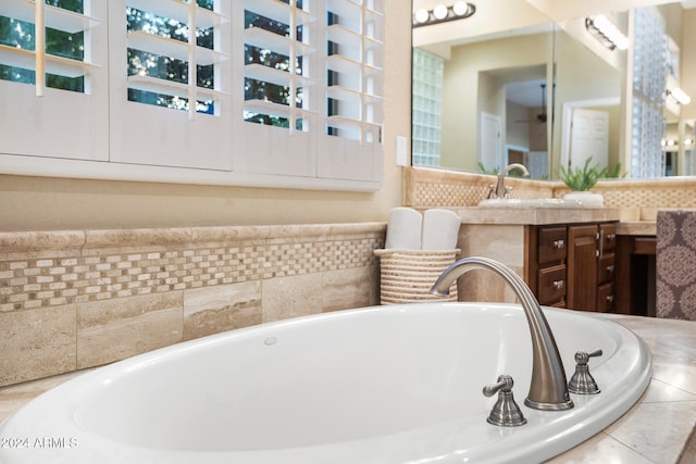 bathroom with vanity and a relaxing tiled tub