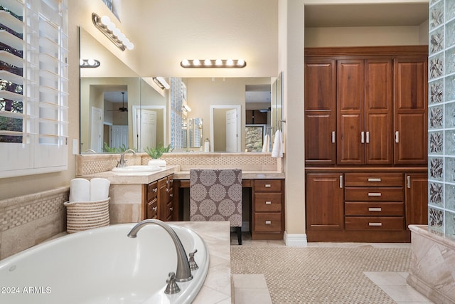 bathroom with vanity, a relaxing tiled tub, and tile patterned flooring