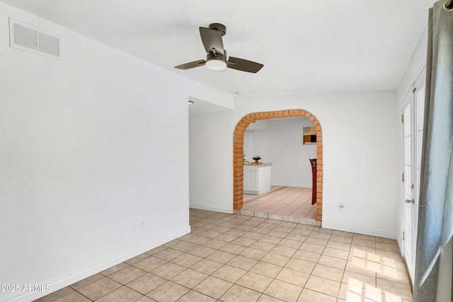 625 S Daley, Mesa, AZ 85204 - empty room with arched walkways, ceiling fan, light tile patterned flooring, and baseboards