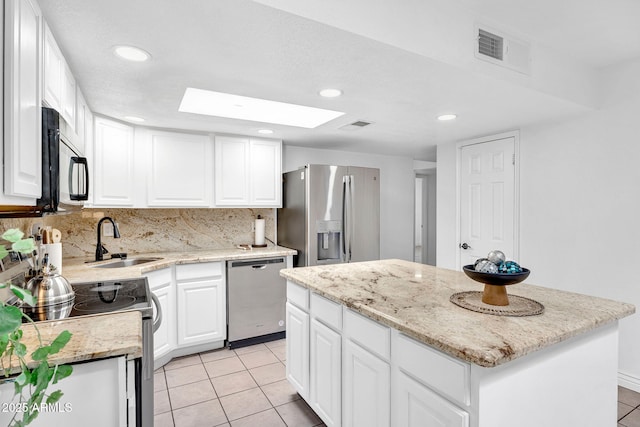 625 S Daley, Mesa, AZ 85204 - kitchen with stainless steel appliances, a sink, a center island, a skylight, and light tile patterned floors
