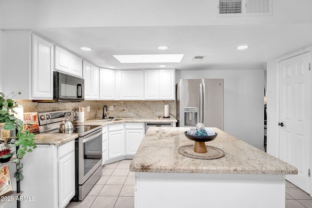625 S Daley, Mesa, AZ 85204 - kitchen featuring appliances with stainless steel finishes, light tile patterned flooring, a sink, a center island, and a skylight