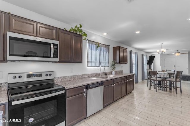 9442 E Silo Rd, Florence, AZ 85132 - kitchen featuring appliances with stainless steel finishes, a sink, dark brown cabinetry, a chandelier, and recessed lighting