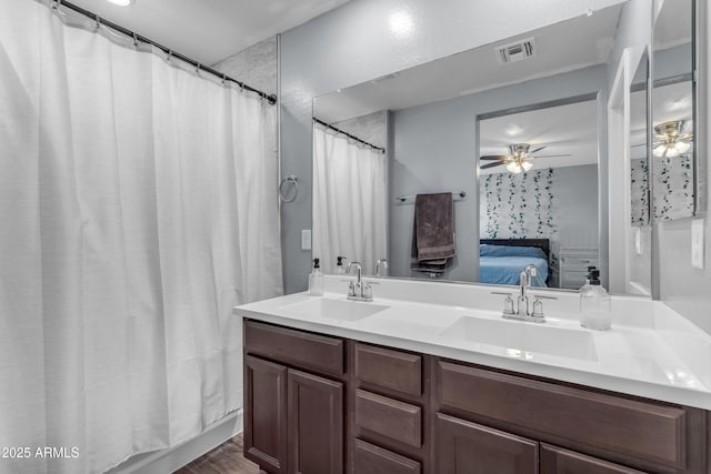 9442 E Silo Rd, Florence, AZ 85132 - ensuite bathroom with double vanity, a ceiling fan, a shower with curtain, and wood finished floors