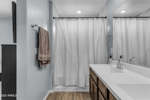 9442 E Silo Rd, Florence, AZ 85132 - bathroom featuring double vanity, wood finished floors, shower / tub combo with curtain, and baseboards