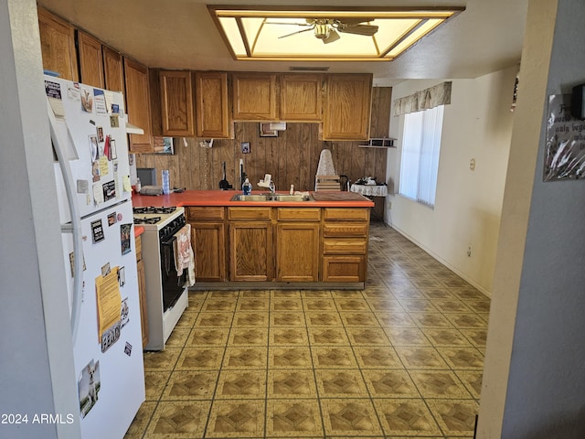 kitchen with kitchen peninsula, white appliances, and sink