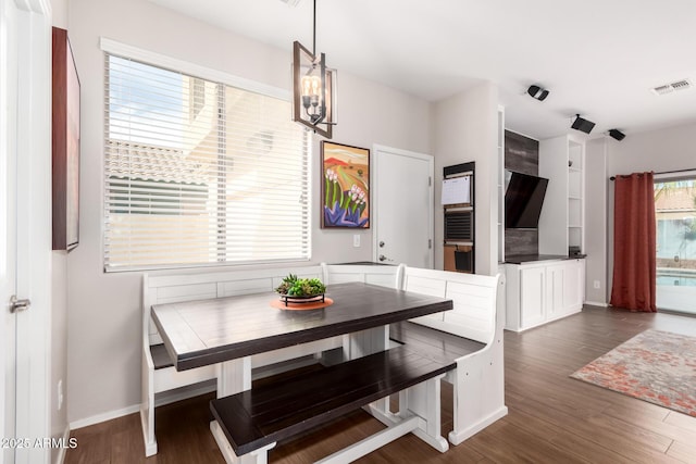 dining room featuring dark wood-style floors, visible vents, and baseboards