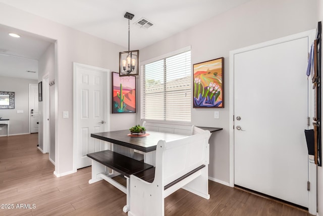 dining space featuring a chandelier, visible vents, light wood-style flooring, and baseboards