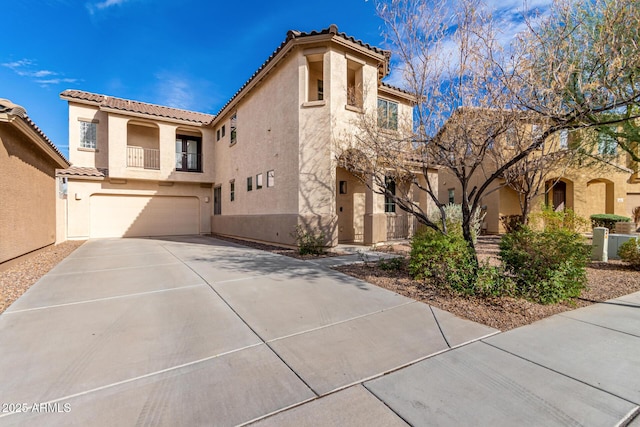 mediterranean / spanish house with a garage, a tile roof, and stucco siding