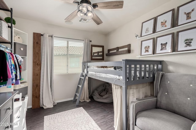 bedroom with a ceiling fan, visible vents, baseboards, and wood finished floors