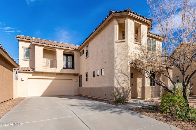 mediterranean / spanish house with concrete driveway, a balcony, a tiled roof, an attached garage, and stucco siding