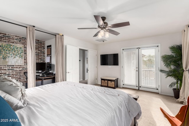 bedroom featuring access to exterior, carpet flooring, brick wall, and a ceiling fan