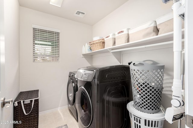 laundry room featuring laundry area, visible vents, baseboards, washing machine and dryer, and light tile patterned flooring