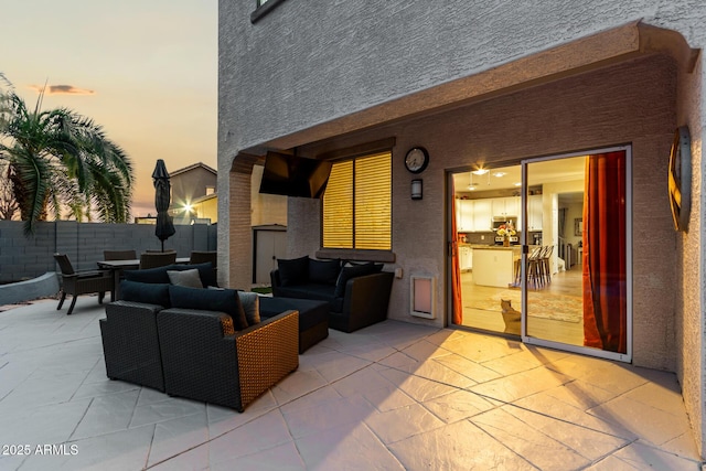 patio terrace at dusk featuring fence and an outdoor hangout area