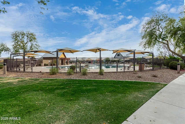 view of playground with a yard, fence, and a fenced in pool