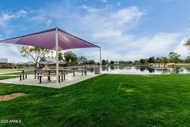 view of home's community with a water view and a yard