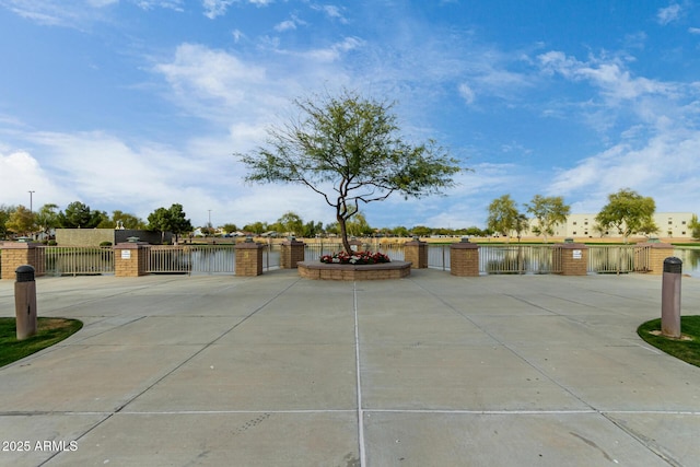 exterior space featuring a water view, a fenced front yard, and a gate