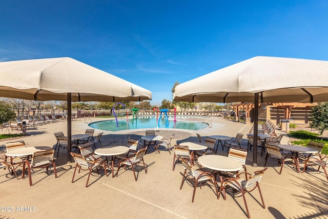 pool with a patio area and fence