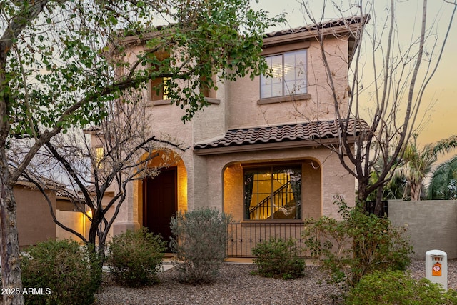 mediterranean / spanish-style home with a tiled roof and stucco siding