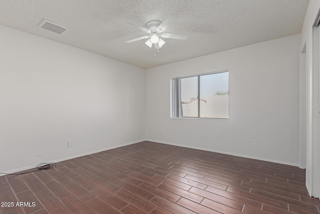 empty room with baseboards, a ceiling fan, visible vents, and wood tiled floor