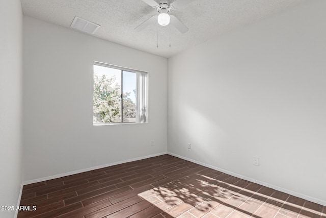 spare room featuring visible vents, a ceiling fan, wood tiled floor, a textured ceiling, and baseboards