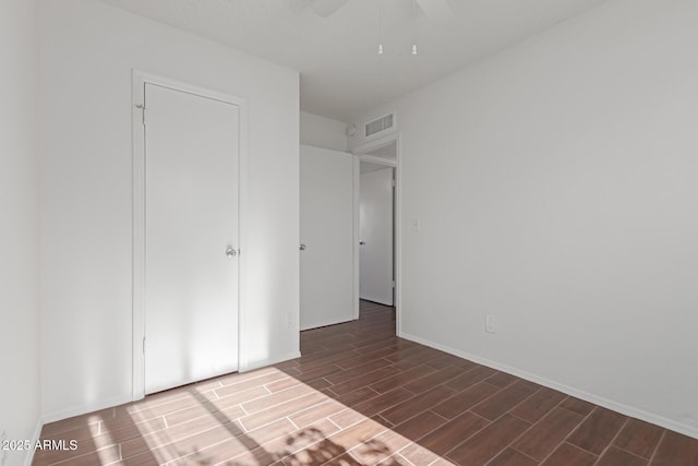 unfurnished bedroom with wood finish floors, visible vents, and a ceiling fan