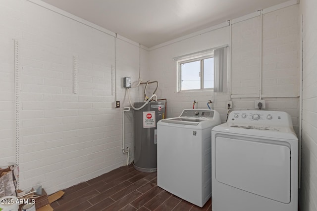 clothes washing area featuring laundry area, separate washer and dryer, wood finish floors, and electric water heater