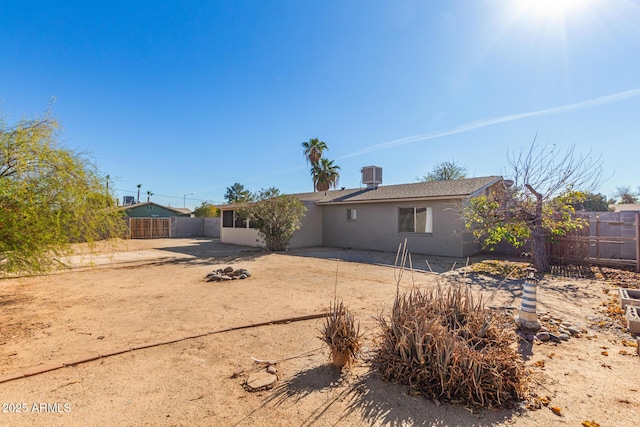 rear view of house with a fenced backyard and central air condition unit