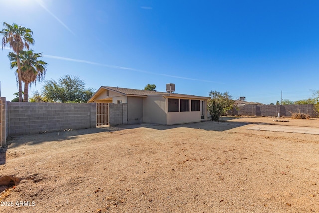 rear view of property featuring cooling unit and a fenced backyard