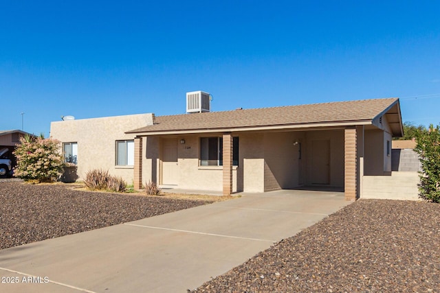 ranch-style home with driveway, central air condition unit, a shingled roof, and stucco siding