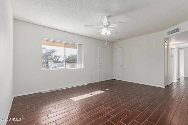 empty room with ceiling fan and a textured ceiling