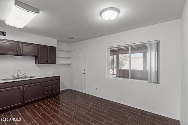 kitchen featuring dark hardwood / wood-style flooring, dark brown cabinetry, and sink