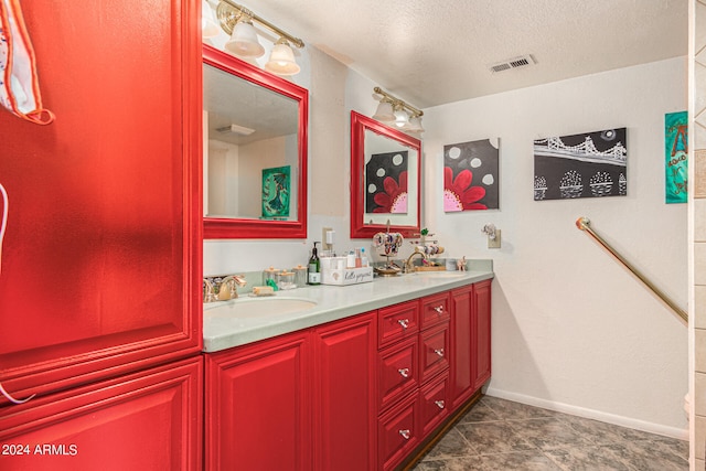 bathroom featuring a textured ceiling, vanity, and tile patterned floors