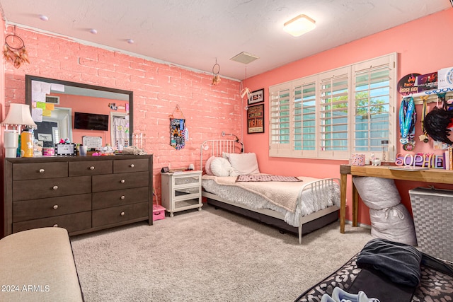 bedroom featuring carpet floors and brick wall