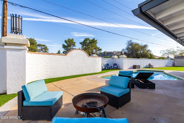 view of patio / terrace with an outdoor fire pit and a fenced in pool