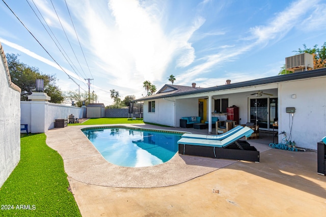 view of swimming pool featuring a patio, a lawn, a shed, and an outdoor hangout area