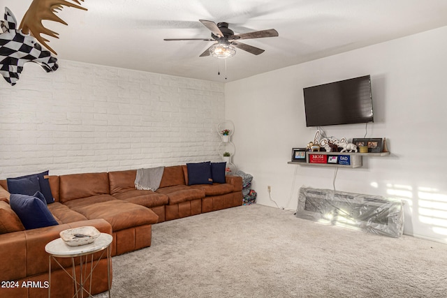 living room with carpet floors, ceiling fan, and brick wall