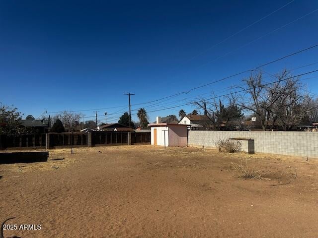 view of yard featuring a storage shed, an outdoor structure, and a fenced backyard