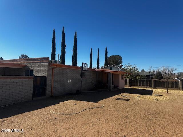 rear view of property featuring fence