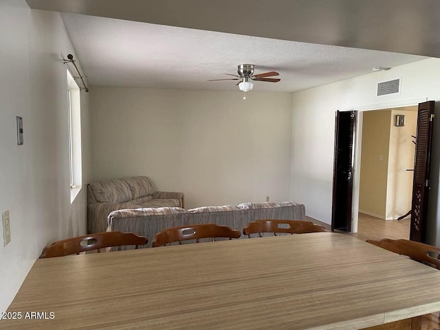 unfurnished room with visible vents, a textured ceiling, and a ceiling fan