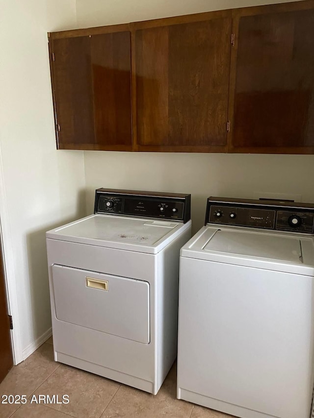 laundry room with light tile patterned floors, cabinet space, and separate washer and dryer