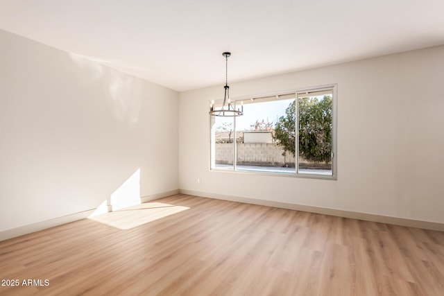 unfurnished dining area with light wood-type flooring and a notable chandelier