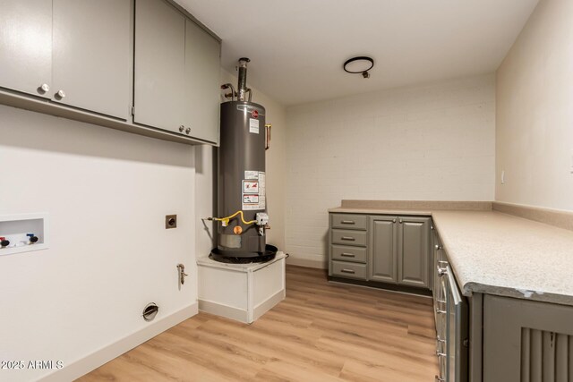 laundry room featuring cabinets, washer hookup, water heater, electric dryer hookup, and light hardwood / wood-style flooring