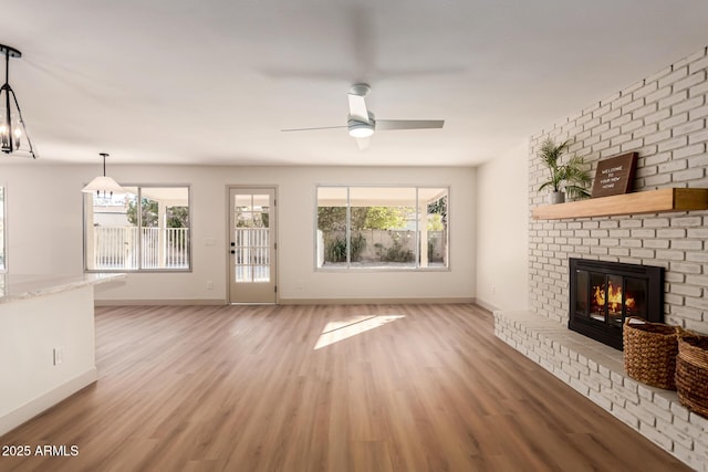 unfurnished living room featuring ceiling fan, a fireplace, and hardwood / wood-style flooring