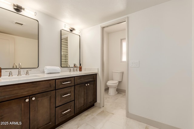 bathroom featuring toilet, a textured ceiling, and vanity