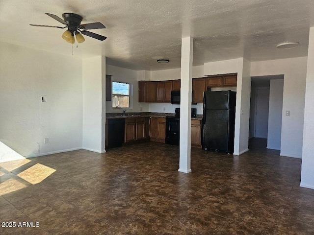 kitchen with dark countertops, open floor plan, a textured ceiling, black appliances, and a sink